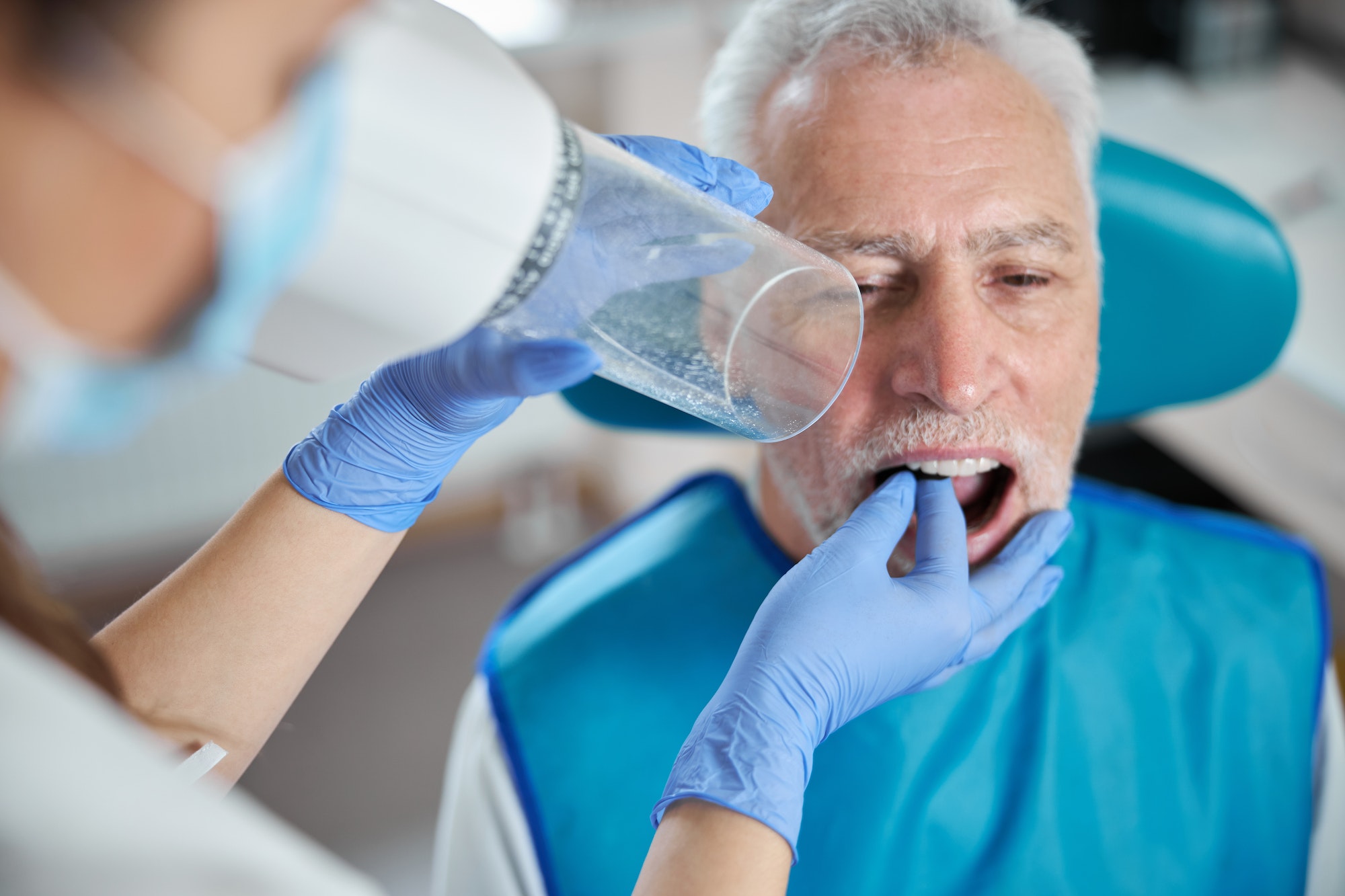 senior citizen keeping his mouth open for a dental x ray